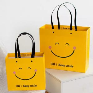 China ISO Shock Resistant Smile Face Kraft Paper Bags Yellow Square Bottom Paper Bag on sale